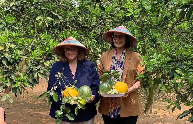 Hai Thứ trưởng Bộ Nông nghiệp Hoa Kỳ, bà Alexis Taylor (ảnh, trái) và bà Jenny Moffitt (ảnh, phải) trong vườn bưởi của ông Nguyễn Như Hảo và Nguyễn Trọng Nhân ở xã Cát Quế, Hoài Đức